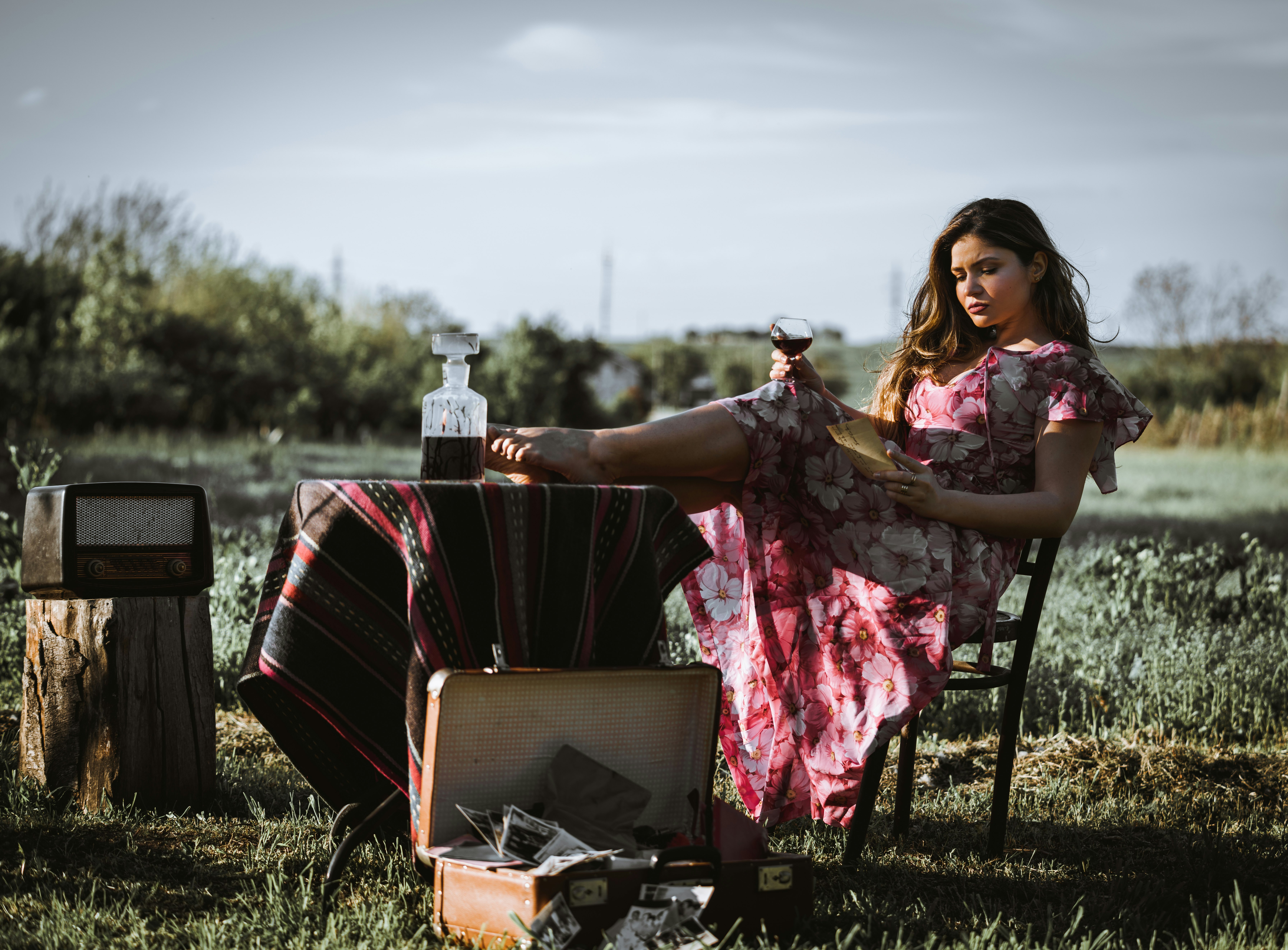 woman wearing pink and white dress sitting on chair outdoors